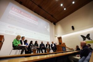 A group of people seated in a row on a stage