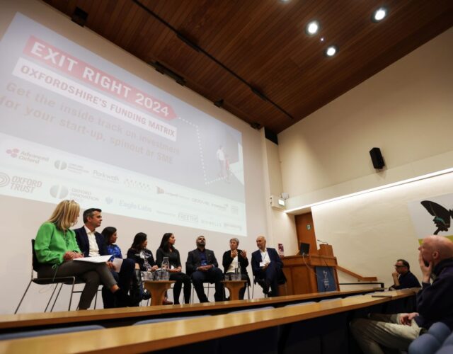 A group of people seated in a row on a stage