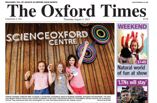 Snapshot of newspaper front page featuring photo of three girls of Big Science Event winning team