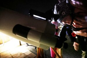 Children looking through telescope at the night sky