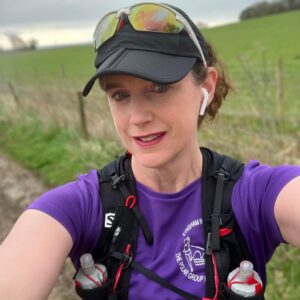 Selfie of woman in running gear with mountain in background