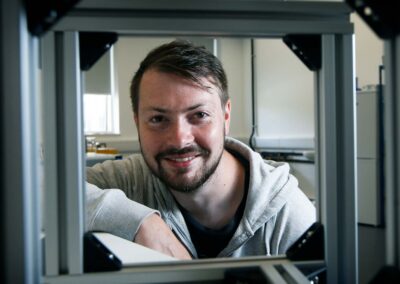 A portrait of Alex Greenhalgh from Spintex looking through a piece of equipment