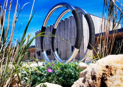 Exterior of the Wood Centre of Innovation showing the wood-clad building, planting and sculpture.