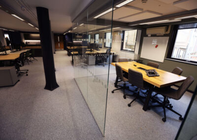A six person meeting table and chairs is sectioned off within one of the office areas at the Oxford Centre for Innovation.