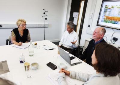 A meeting taking place at the large board meeting table within the Wood Centre for Innovation