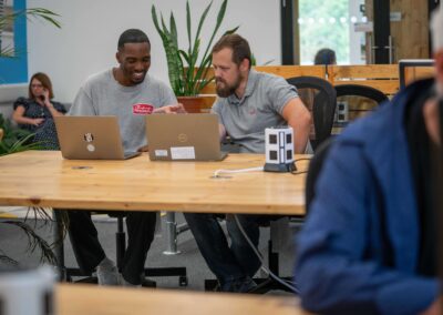 Colleagues work on a project together, sitting at the co-working desks within the Barclays Eagle Labs at the Wood Centre for Innovation.