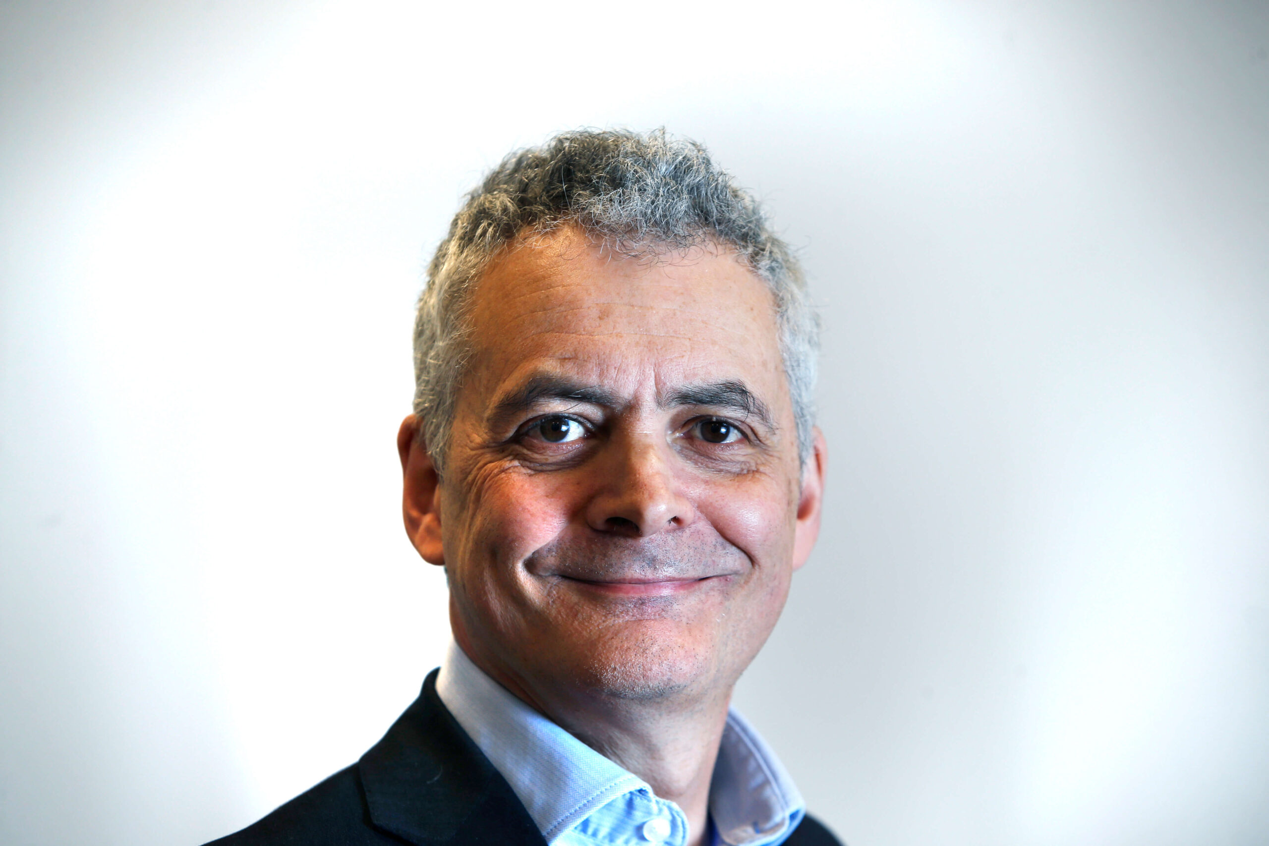 A portrait of portrait Jonathon Flint CBE, Trustee, against a white background.