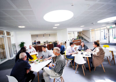 People eating lunch and having meetings within the foyer of the Wood Centre for Innovation