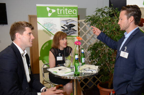 The team from Triteq sit in front of a branded baner at the Oxford Centre for Innovation.