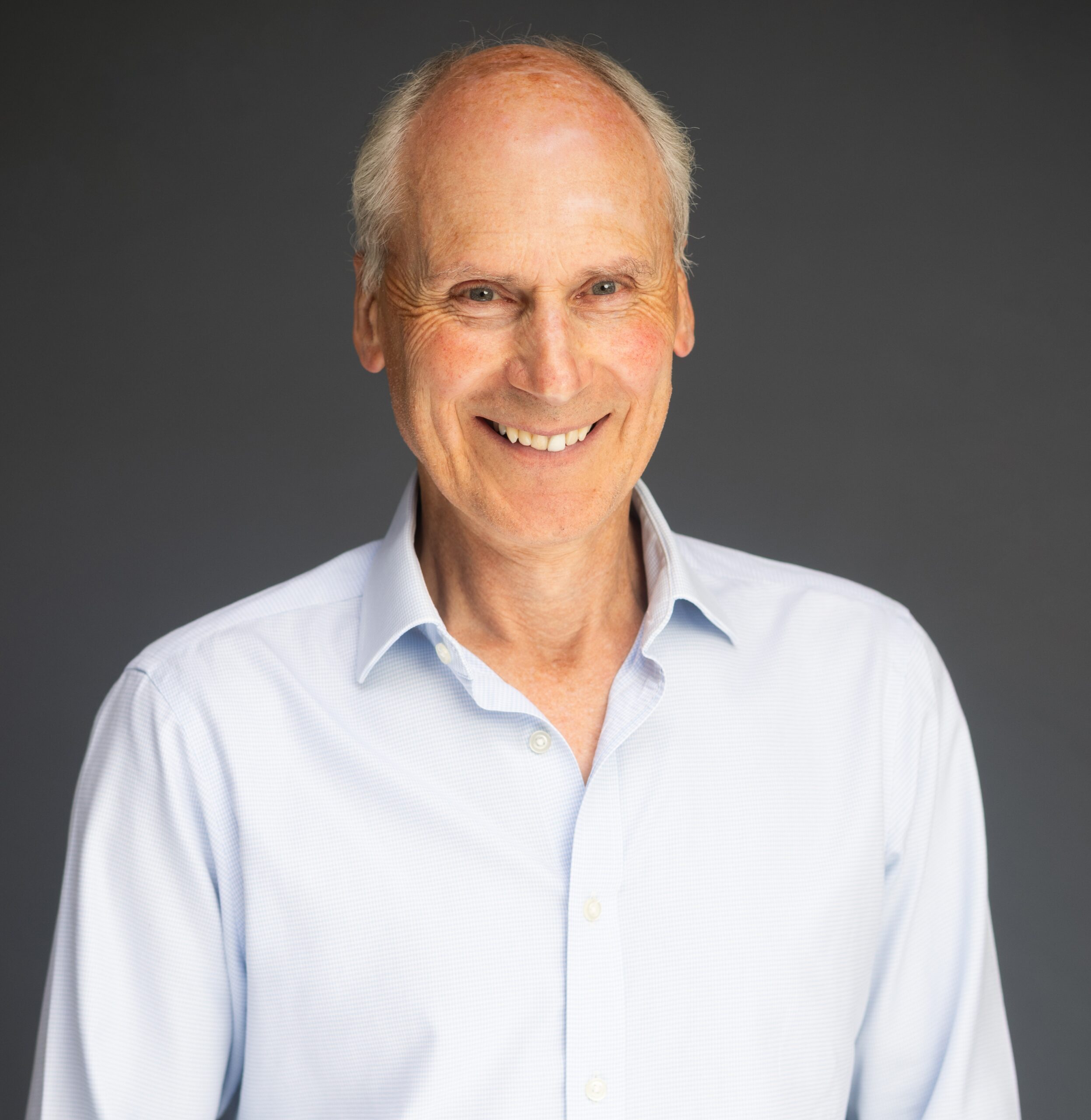 Portrait of trustee, David Carr, with a grey background.