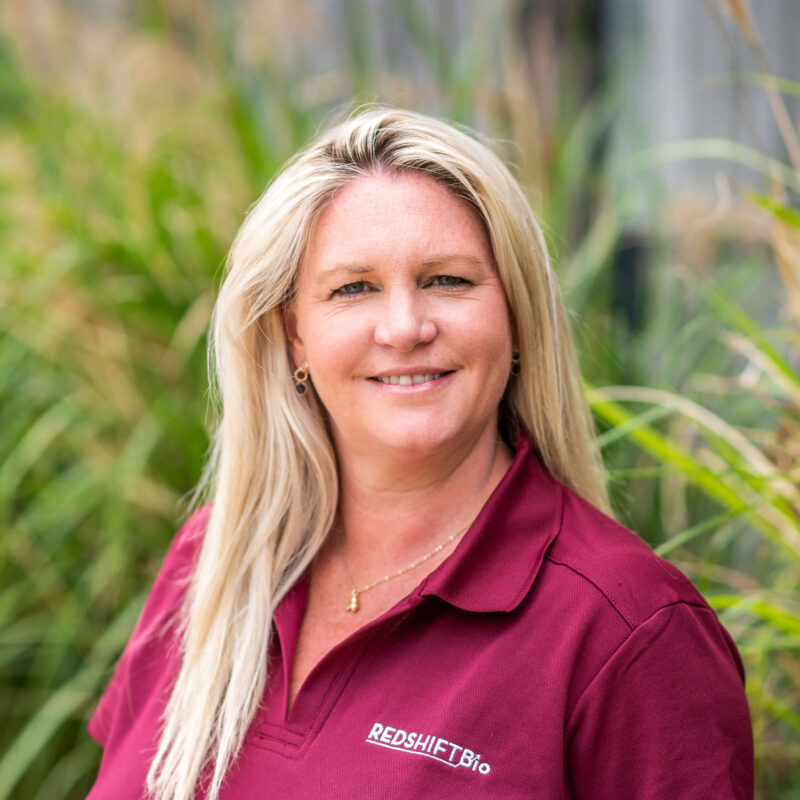 Portrait of Natalie Jackson, Marketing and Commercial Manager, UK outside the Wood Centre for Innovation with foliage in the background.
