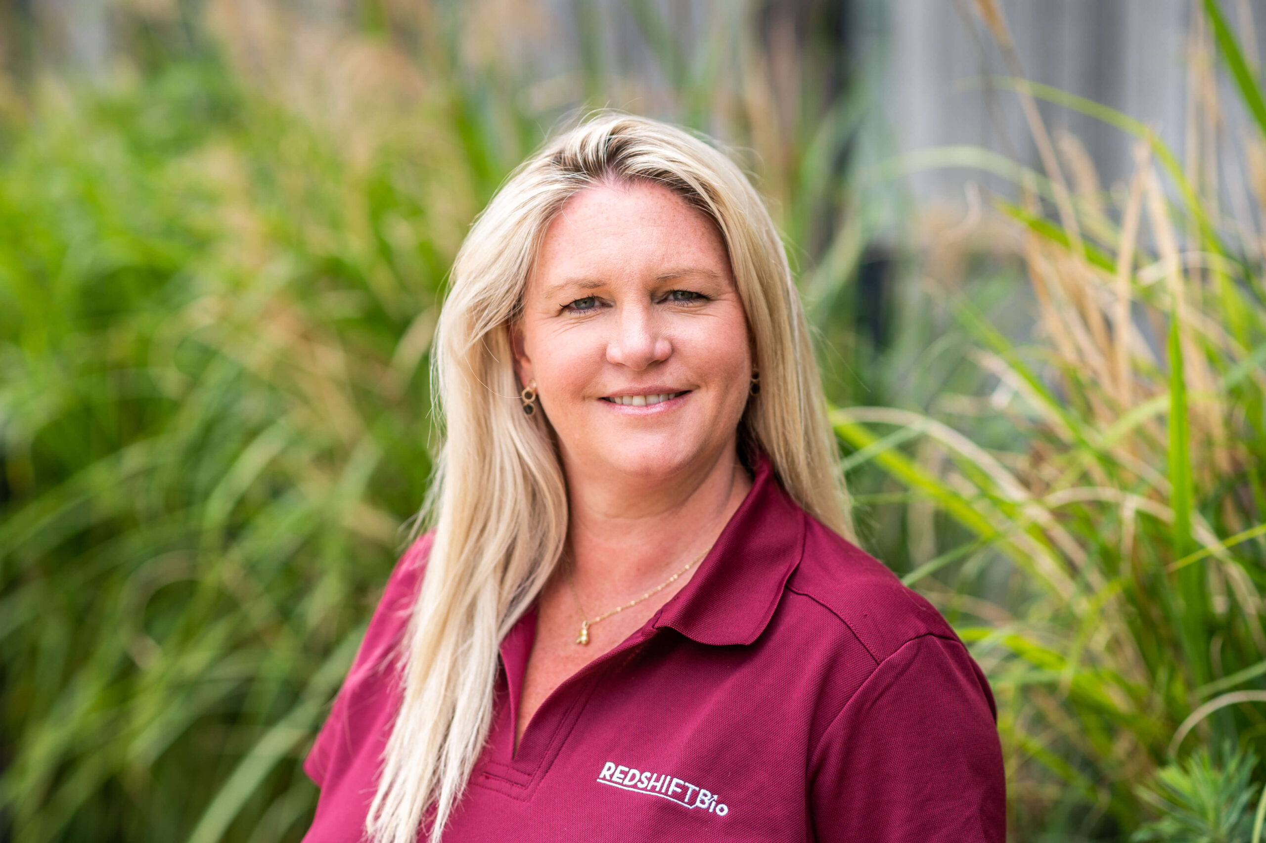 Portrait of Natalie Jackson, Marketing and Commercial Manager, UK outside the Wood Centre for Innovation with foliage in the background.