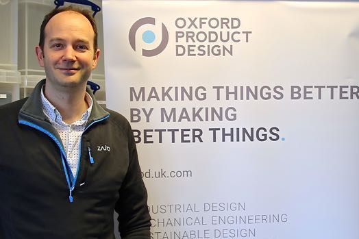 Rupert Wilkinson, MD of Oxford Product Design, stands in-front of a branded banner at the Oxford Centre for Innovation.